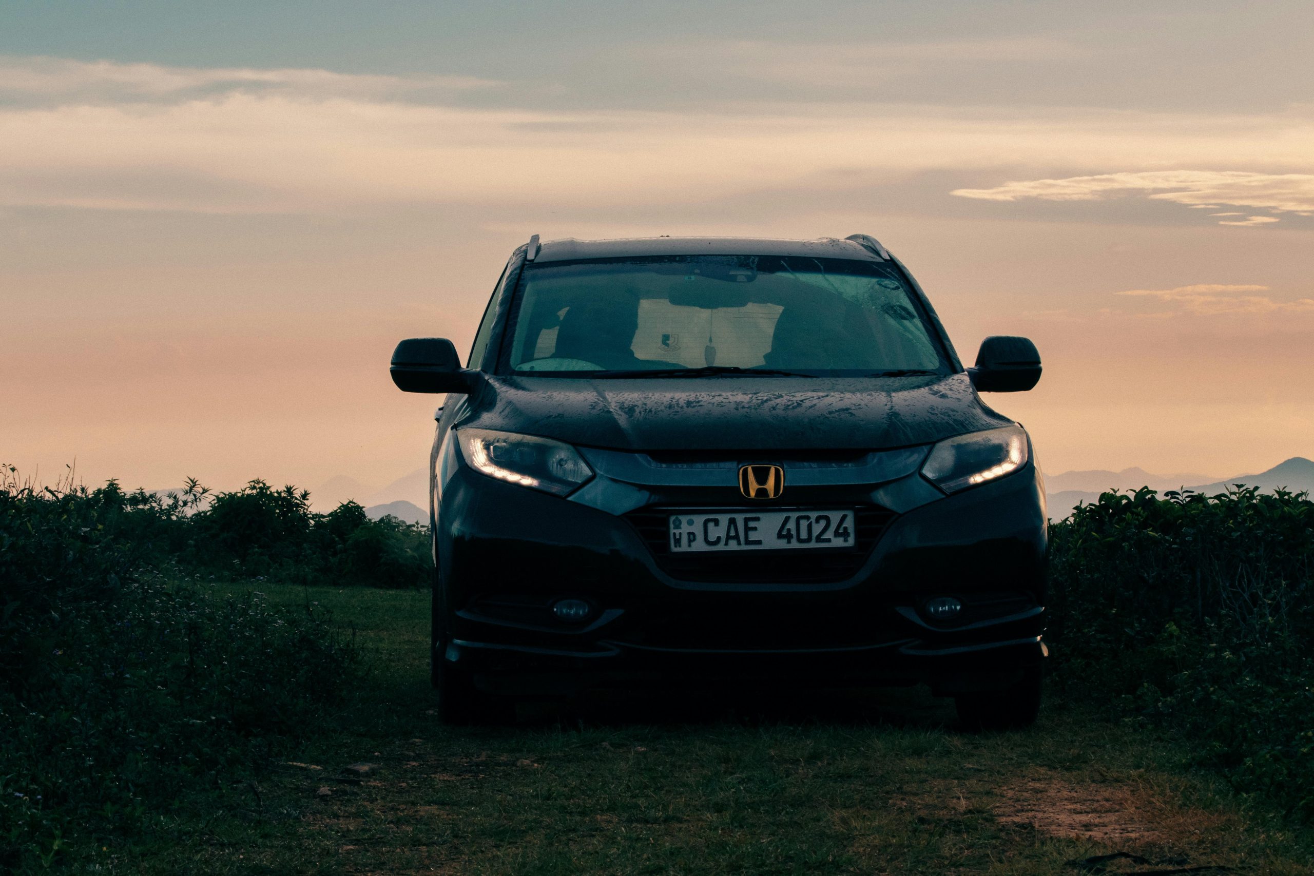 Front view of a Honda SUV in Madulsima, Sri Lanka, at sunset, capturing a serene rural backdrop.